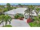 Charming yellow home with a white tile roof, paver driveway, and lush tropical landscaping, near the water at 44 Waterford Dr, Englewood, FL 34223