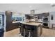 Modern kitchen with dark wood cabinets, stainless steel appliances, granite countertops, and a large island with seating at 44 Waterford Dr, Englewood, FL 34223
