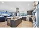 Open kitchen with an island, modern appliances, dark cabinets, and an adjacent living area at 44 Waterford Dr, Englewood, FL 34223