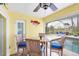 Relaxing patio features a ceiling fan, comfortable seating, and a view of the shimmering pool at 44 Waterford Dr, Englewood, FL 34223