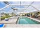 Inviting pool and spa with a screened enclosure and an outdoor dining area overlooking the water at 44 Waterford Dr, Englewood, FL 34223