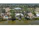 Aerial view of waterfront home featuring a private dock, lush landscaping, and neighborhood views at 4624 Pompano St, Placida, FL 33946