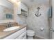A bathroom featuring a sink, toilet, and nautical-themed decor at 5055 N Beach Rd # 208, Englewood, FL 34223