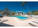 Community pool and lounge area surrounded by lush landscaping at 5055 N Beach Rd # 208, Englewood, FL 34223