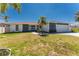 Charming single-Gathering home with a well-manicured lawn, mature palms, and a welcoming entrance at 5232 Conner Ter, Port Charlotte, FL 33981