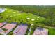 Aerial view of a residential community next to a golf course showing tiled roofs, pools, and tropical landscaping at 5433 White Ibis Dr, North Port, FL 34287