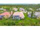 Aerial view of backyard featuring a tiled roof, pool, landscaping, and nearby golf course at 5433 White Ibis Dr, North Port, FL 34287