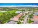 Scenic aerial view of a residential area with tiled roofs, screened lanais and a nearby golf course and lake at 5433 White Ibis Dr, North Port, FL 34287