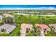 Beautiful aerial view of several homes, landscaping, a lake, and a golf course in the background of this community at 5433 White Ibis Dr, North Port, FL 34287