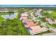 An aerial view of a neighborhood featuring tile roofs, screened patios, and pools near a serene lake and golf course at 5433 White Ibis Dr, North Port, FL 34287