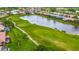 An aerial view of a golf course and a pond with residential homes in the background with beautiful landscaping at 5433 White Ibis Dr, North Port, FL 34287