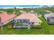 Aerial view showcases a tiled roof, screened-in pool, and vibrant green lawn in this backyard at 5433 White Ibis Dr, North Port, FL 34287