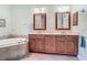 Bathroom with double vanity, soaking tub, and tile surround at 5433 White Ibis Dr, North Port, FL 34287