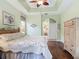 Comfortable bedroom with tray ceiling, ceiling fan, and wood floors at 5433 White Ibis Dr, North Port, FL 34287