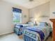 Inviting bedroom with two twin beds, soft lighting and a cheerful beach-themed decor at 5433 White Ibis Dr, North Port, FL 34287