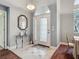 Elegant foyer features tile flooring, a decorative mirror, and a transom window above the front door at 5433 White Ibis Dr, North Port, FL 34287