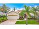 Inviting home with a well-manicured lawn, paver walkway, tropical landscaping, and a two-car garage at 5433 White Ibis Dr, North Port, FL 34287