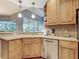 Sunlit kitchen showcasing wood cabinets, stainless dishwasher and scenic outdoor views at 5433 White Ibis Dr, North Port, FL 34287