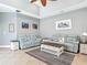 Bright living room with coastal decor, neutral walls, ceiling fan, and comfortable seating at 5433 White Ibis Dr, North Port, FL 34287