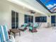 The covered patio features cozy seating, ceiling fans, and views of the lush backyard at 5433 White Ibis Dr, North Port, FL 34287