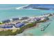 Stunning aerial view of beachfront condos with a boat dock and clear turquoise water at 6030 Boca Grande Cswy # B21, Boca Grande, FL 33921