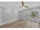 Airy bedroom with balcony access, wood-look floors, and a modern ceiling fan at 6030 Boca Grande Cswy # B21, Boca Grande, FL 33921