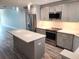 Modern kitchen with gray cabinets, stainless steel appliances, and a large island with white countertop at 6030 Boca Grande Cswy # B21, Boca Grande, FL 33921