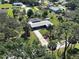 Aerial view showcasing the property's lush landscaping, screened-in pool, and long driveway at 6181 Jack St, Venice, FL 34293