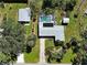 Aerial view showcasing a home with a screened pool, lush landscaping, and detached garage at 6181 Jack St, Venice, FL 34293