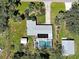 Aerial view of home with a screened-in pool, lush landscaping, and private backyard at 6181 Jack St, Venice, FL 34293
