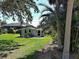 Expansive backyard featuring a charming detached unit surrounded by tropical greenery and palm trees at 6181 Jack St, Venice, FL 34293