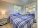 Inviting bedroom with a plaid bedspread, mirrored closet, and a charming bedside table at 6181 Jack St, Venice, FL 34293