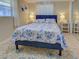 Bright bedroom with a blue floral pattern bedspread, matching rug and two bedside tables with lamps at 6181 Jack St, Venice, FL 34293