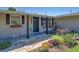 Charming front entrance with stone walkway and colorful landscaping with flowers in window boxes at 6181 Jack St, Venice, FL 34293