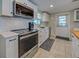 Modern kitchen featuring stainless steel appliances, sleek white cabinetry, and subway tile backsplash at 6181 Jack St, Venice, FL 34293