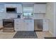Bright kitchen featuring white cabinets, stainless steel appliances, and a neutral-toned backsplash at 6181 Jack St, Venice, FL 34293