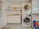 Well-equipped laundry room with stacked washer and dryer, sink, and plenty of storage space at 6181 Jack St, Venice, FL 34293