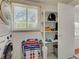 Functional laundry area with modern appliances, shelving, and storage for laundry essentials and accessories at 6181 Jack St, Venice, FL 34293