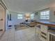 Inviting living room featuring tile floors, a sofa, table and view into bedroom at 6181 Jack St, Venice, FL 34293