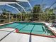 Screened-in pool featuring a brick-lined design, complemented by surrounding lush greenery, perfect for relaxation and enjoyment at 6181 Jack St, Venice, FL 34293