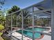 Screened-in pool area featuring clear blue water and a seating area for relaxing at 6181 Jack St, Venice, FL 34293
