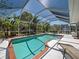 Inviting screened-in pool with well-maintained landscaping and an adjacent patio seating area at 6181 Jack St, Venice, FL 34293