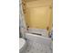Bathroom with yellow tiled walls and a white tub at 6540 Coliseum Blvd, Port Charlotte, FL 33981