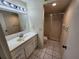 Neat bathroom featuring a vanity, mirror, and walk-in shower with updated tile and fixtures at 6800 Placida Rd # 1004, Englewood, FL 34224
