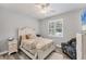 Cozy bedroom with a white distressed bed frame, ceiling fan, and natural light at 7108 Harle Ave, North Port, FL 34291