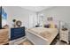 Cozy bedroom featuring shuttered window, stylish blue dresser, and a comfortable bed with decorative pillows at 7108 Harle Ave, North Port, FL 34291