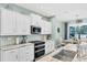 Updated kitchen featuring white cabinets, stone countertops, and stainless steel appliances at 7108 Harle Ave, North Port, FL 34291