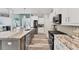 Bright and modern kitchen with white cabinets, stainless steel appliances, and stone countertops at 7108 Harle Ave, North Port, FL 34291