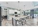 Modern kitchen and dining area featuring white cabinets, stainless appliances, and stone countertops at 7108 Harle Ave, North Port, FL 34291