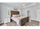 Light-filled main bedroom with tray ceiling, fan, shuttered windows, wood-look floors, and en-suite access at 7108 Harle Ave, North Port, FL 34291